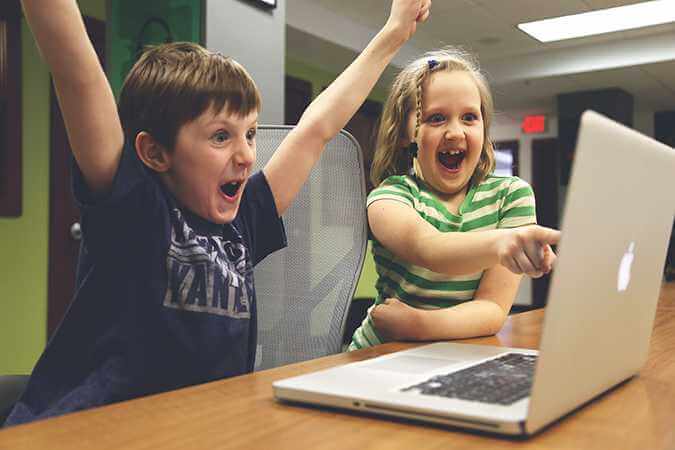 Children excitedly staring at a computer screen