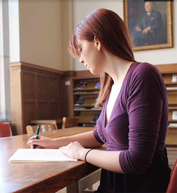 a woman writing at a desk