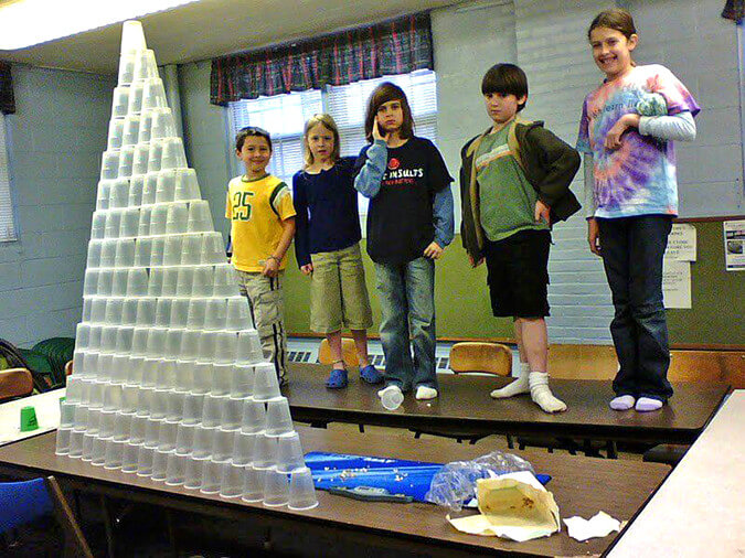 Students standing by stacked cups