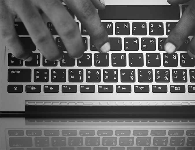 A person's hands typing on a keyboard