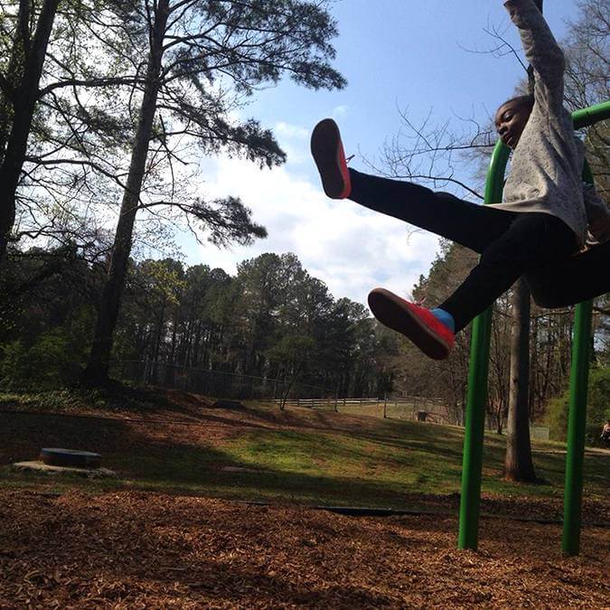 A young person jumping off a swing set
