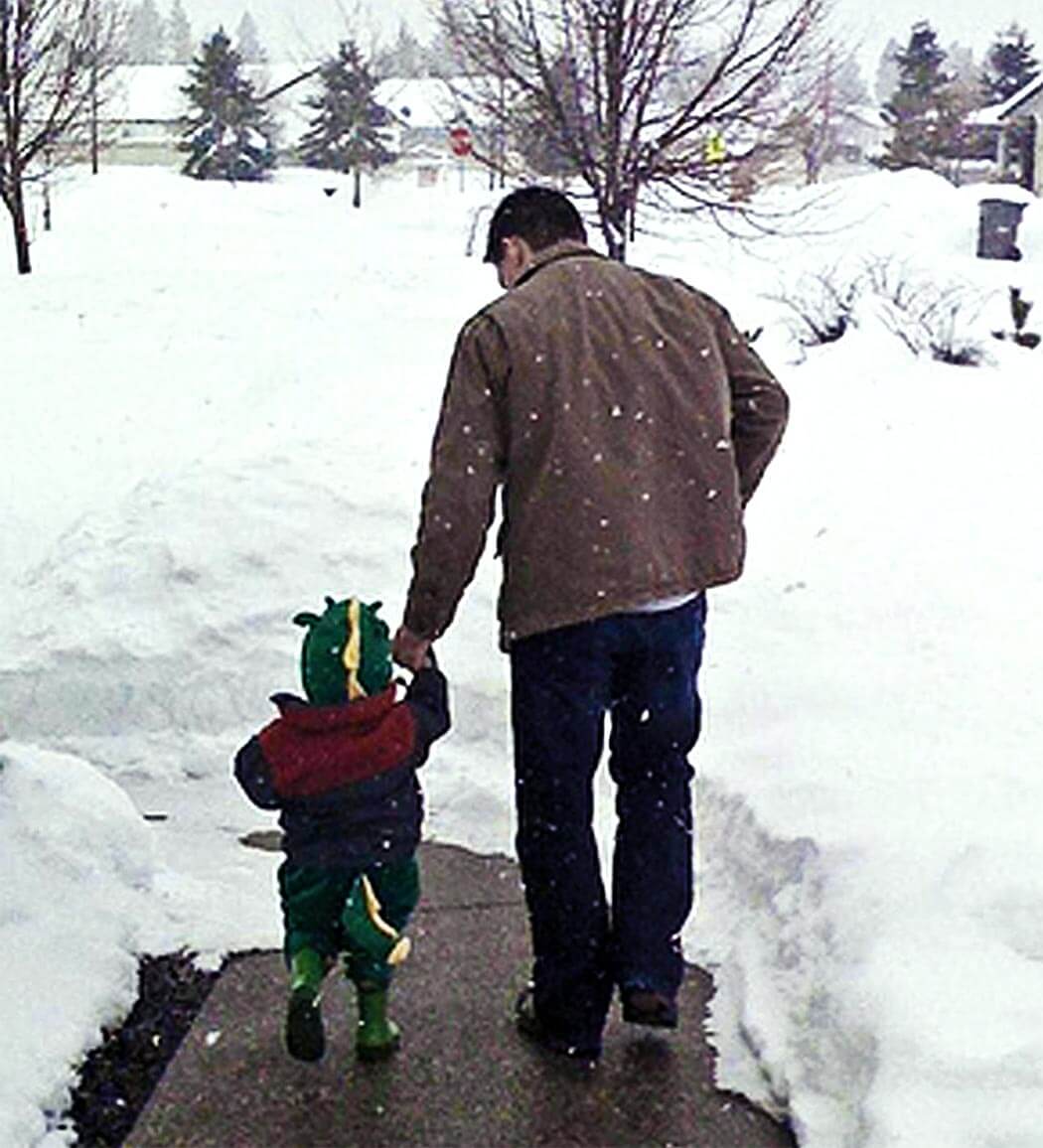 child and adult walking in the snow