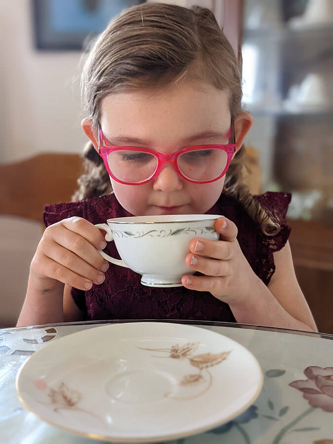 A child drinking from a teacup