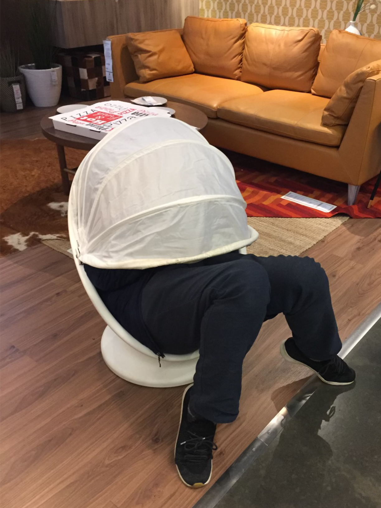 photo of a teen sitting in a pod chair in Ikea, face obscured